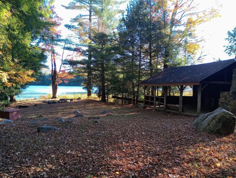 a small wooden building by a path leading to a lake