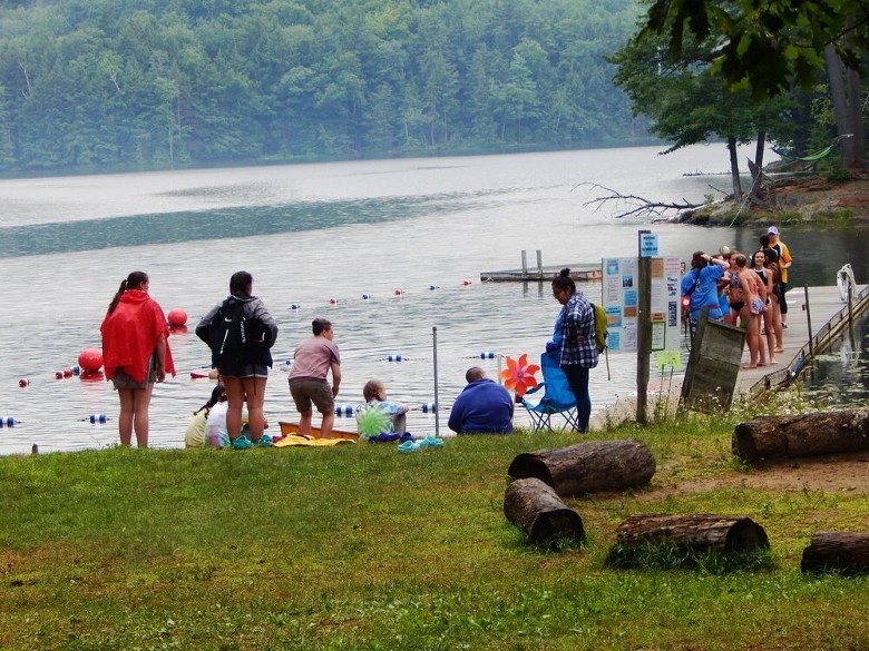 group of people by a lake beach and dock