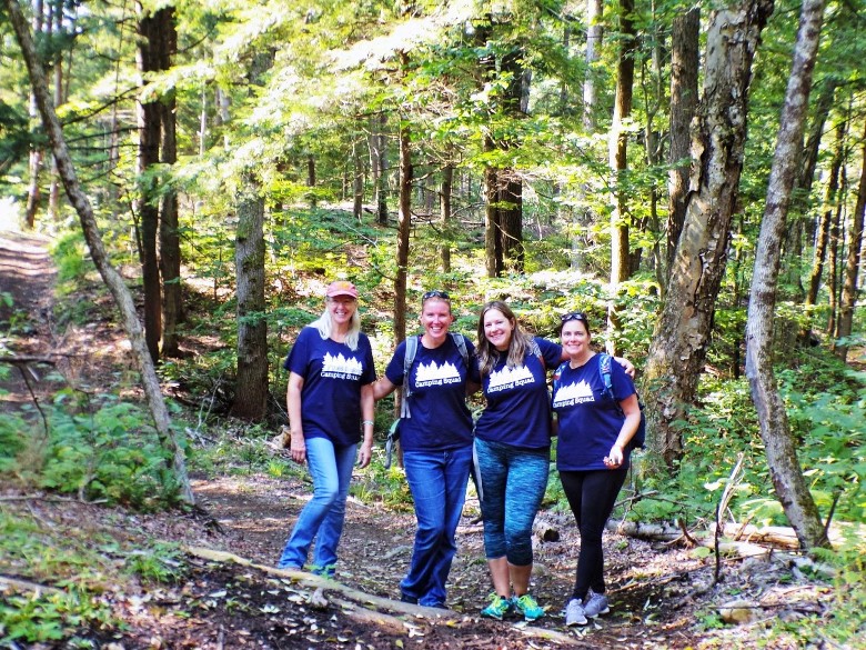 group of four women in the woods