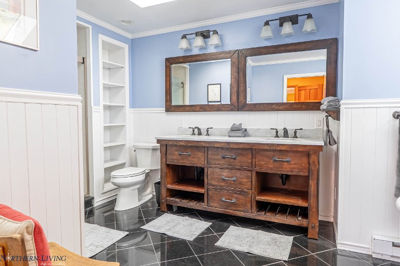 a modern bathroom with a toilet and two sinks and mirrors