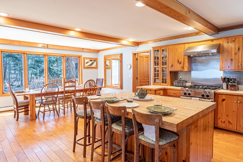 The large eat-in kitchen is the heart of the home, featuring two dining room tables that can seat up to 20 people, making it perfect for large family meals or gatherings.
