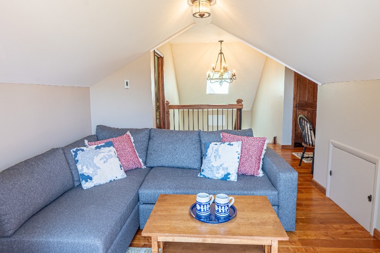 A loft area adjacent to this bedroom features a queen pullout sofa, offering extra sleeping space or a quiet nook for relaxation.