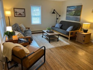 a living room with couches and chair, and a table and lamps