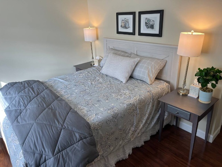 a house bedroom with a bed, and two nightstands with two lamps turned on