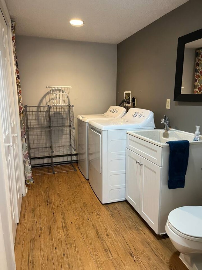a laundry room with a washer and dryer, and a sink and toilet