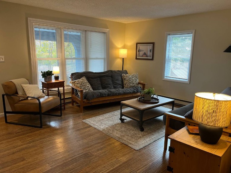 a living room with a couch, chair, table, and lamps
