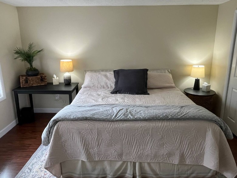a house bedroom with a bed, and two nightstands with two lamps turned on