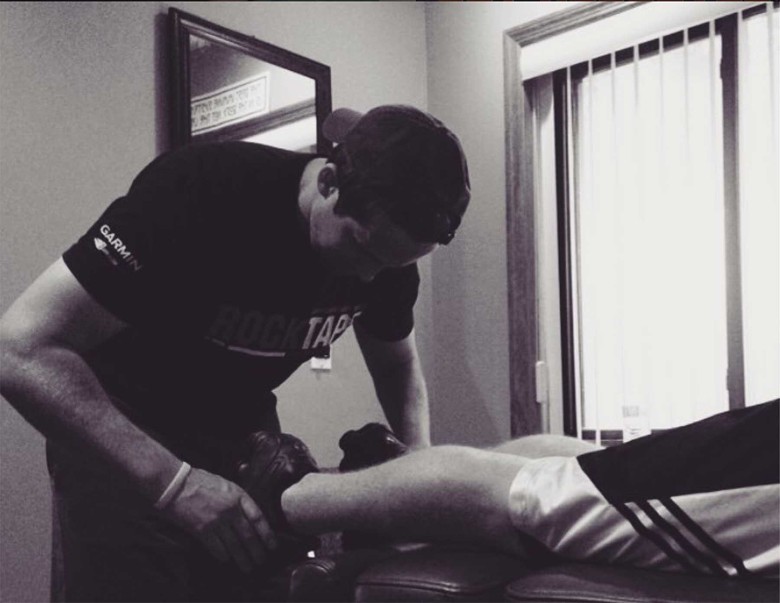 a chiropractor helping a patient's leg muscle