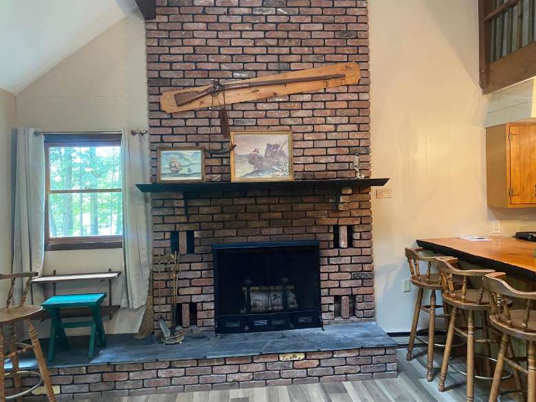 a brick fireplace with a kitchen to the left