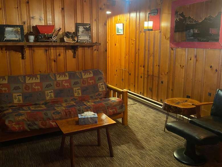 a couch and table in a wood-paneled room