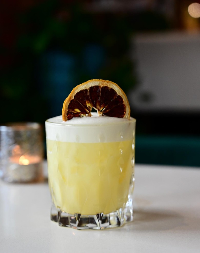 pale yellow cocktail with blood orange