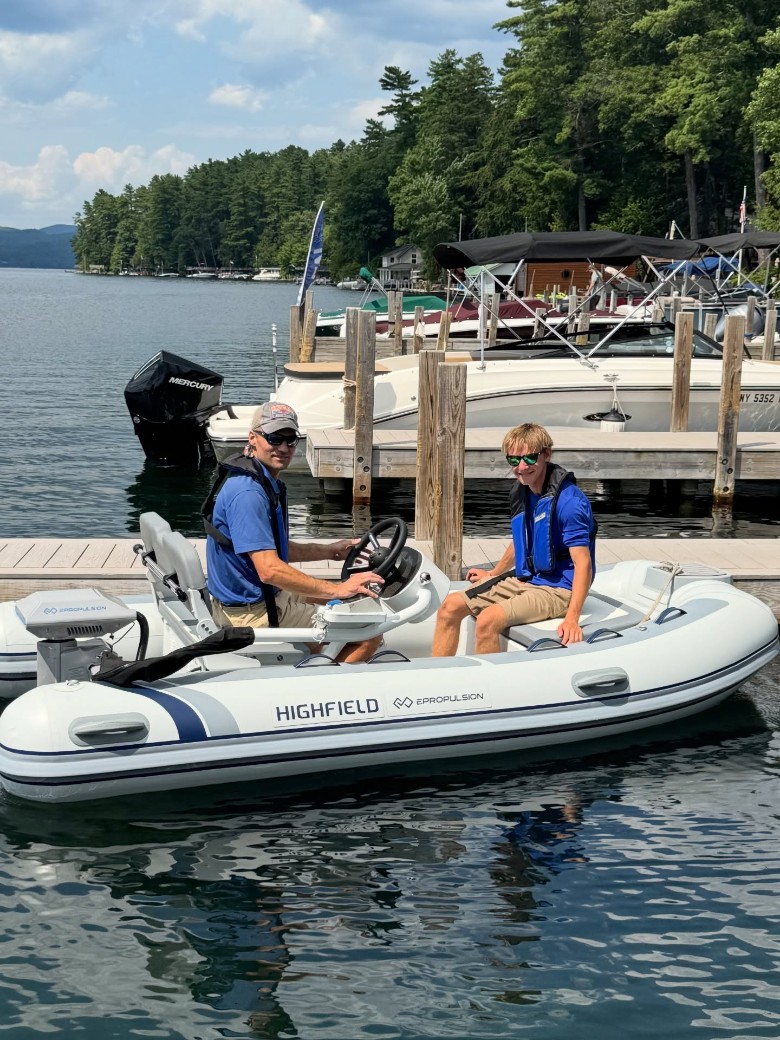 two people in a small boat at a dock