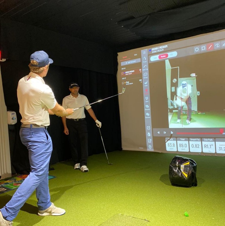man swinging at indoor golf simulator