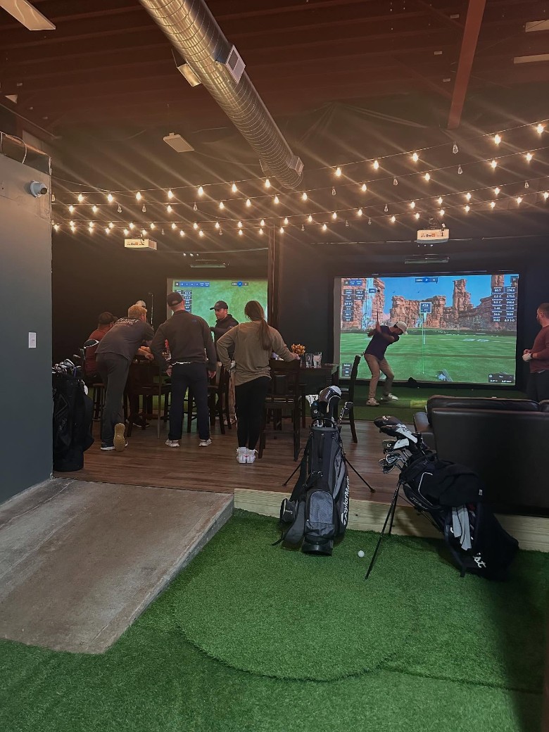 people at indoor golf simulators