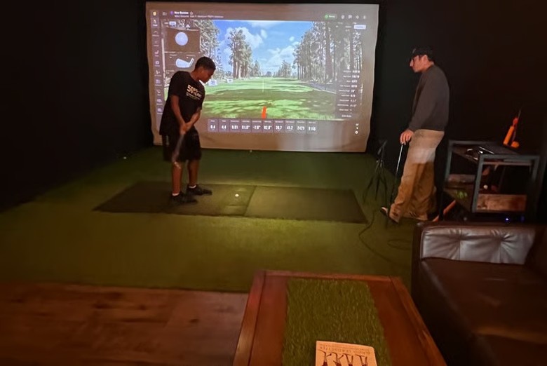 a teenage boy at an indoor golf simulator