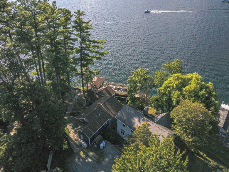 aerial view of a lakefront home and a lake with a boat on it