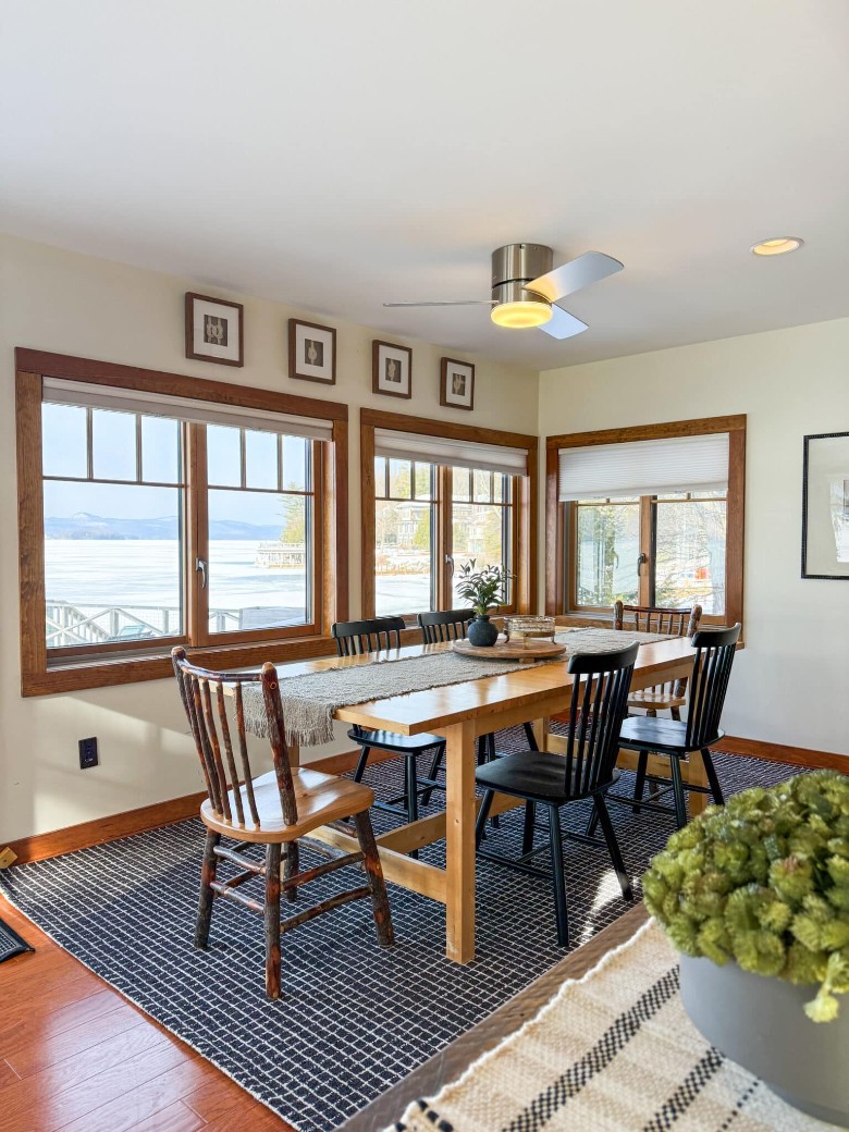 a dining room table with windows on the walls