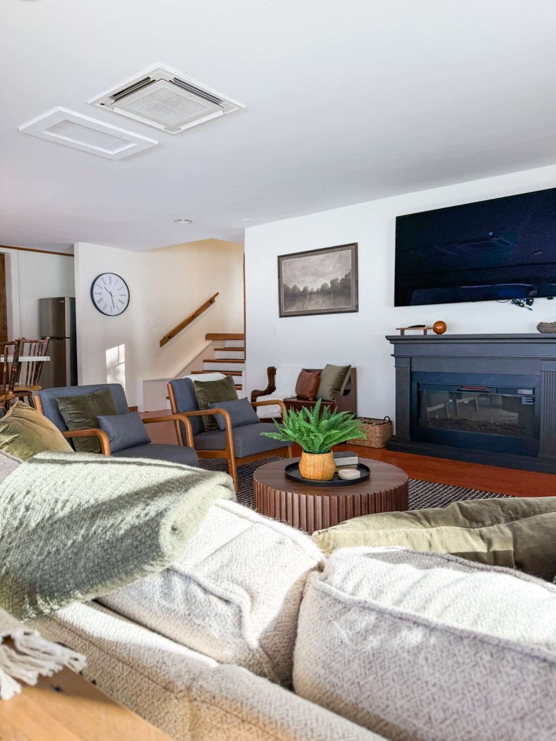 a living room with a fireplace, furniture, and TV on wall