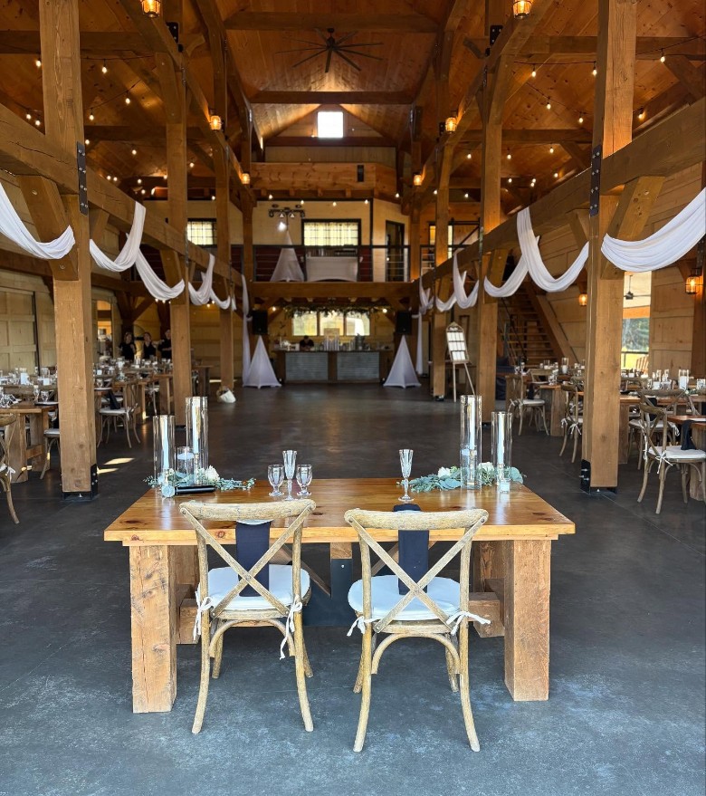 inside of a rustic barn wedding venue with tables and seating