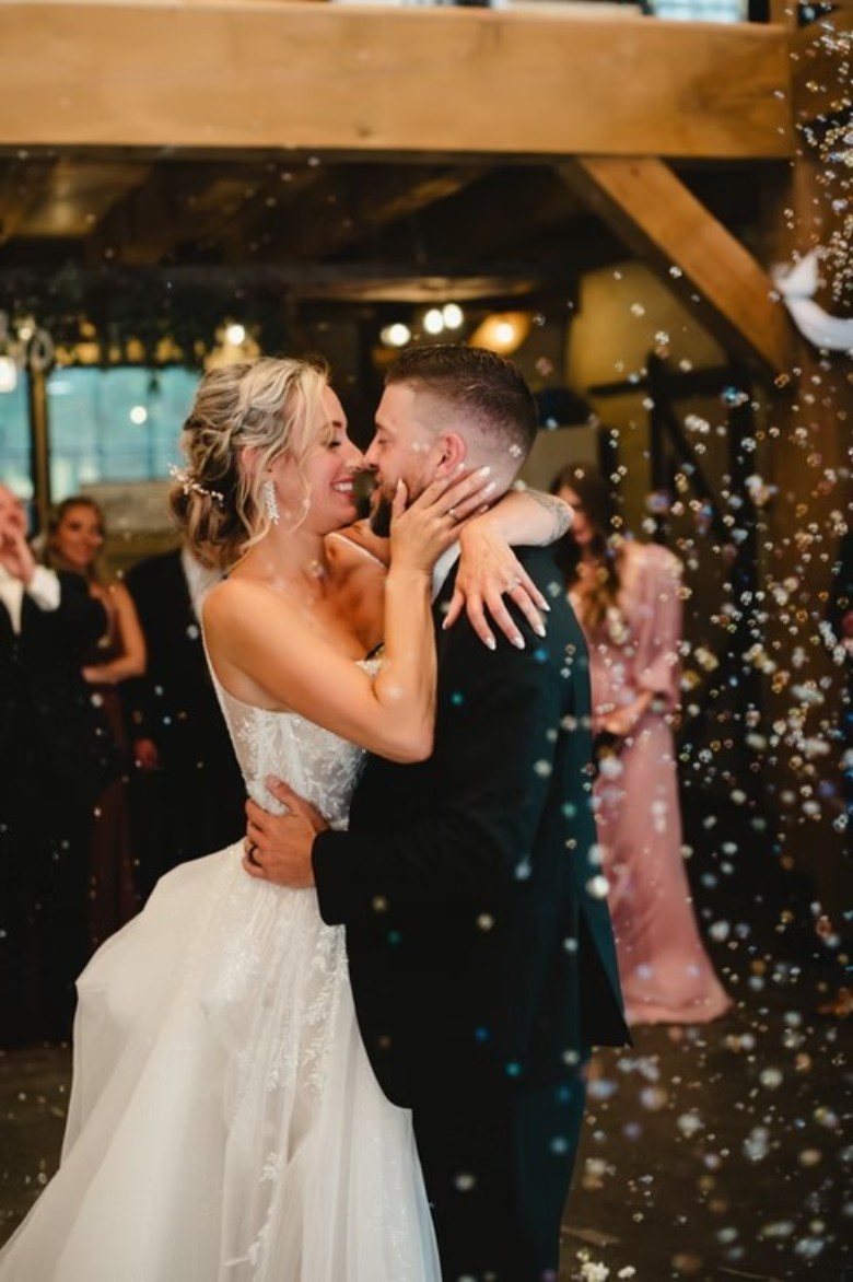 bride and groom embracing inside a rustic wedding venue