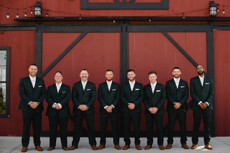 groomsmen outside a red barn