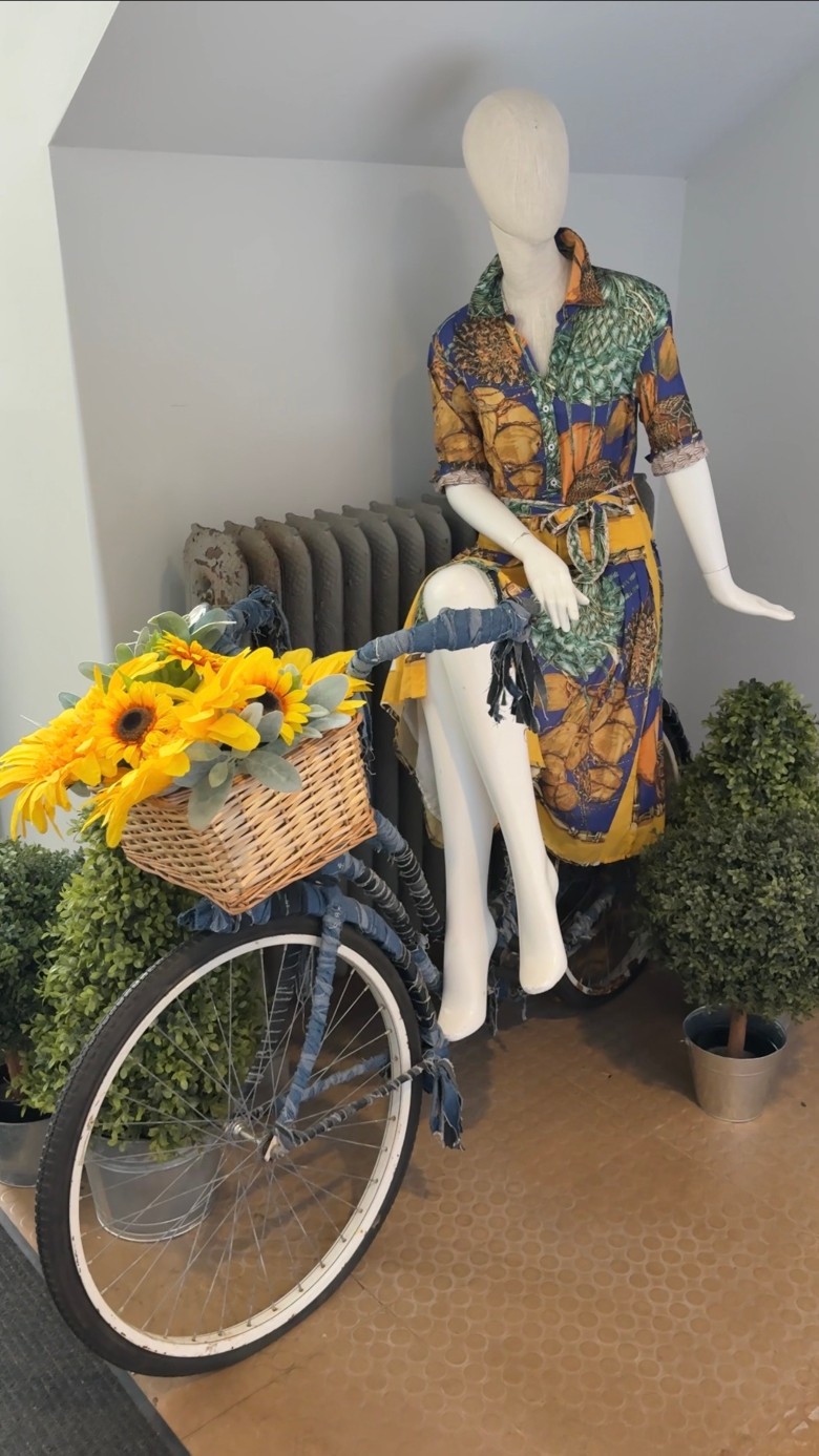 a mannequin wearing a dress on a bike outdoors