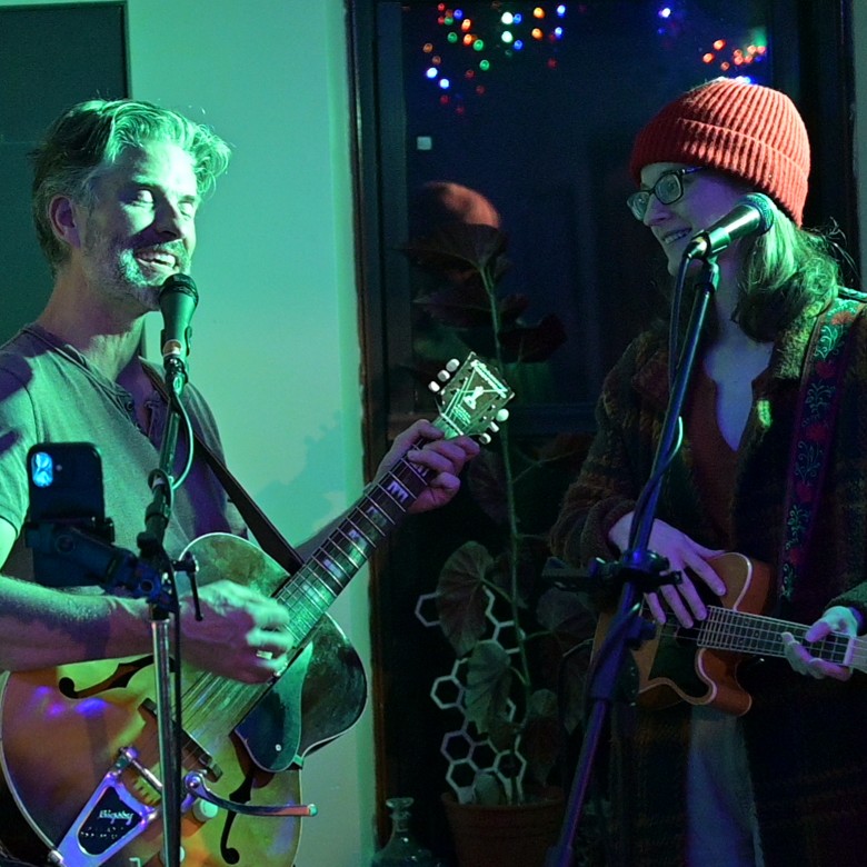 a man playing the guitar with a woman playing a smaller guitar