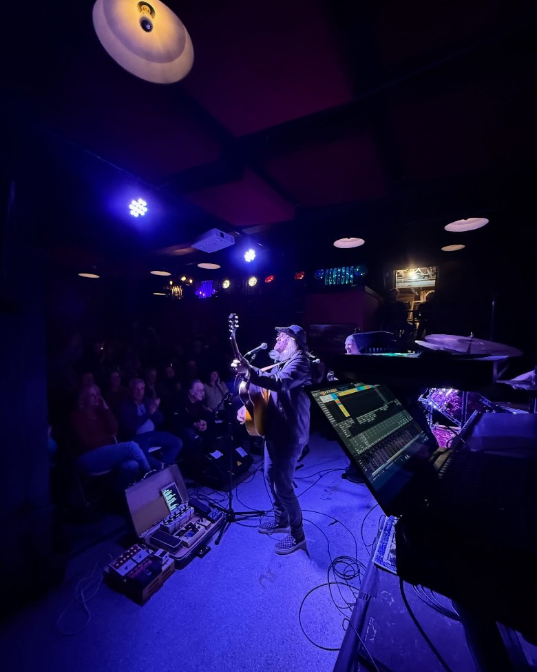 an indoor concert with a guitarist