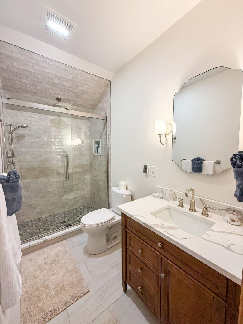 a large bathroom with a glass door shower, a toilet, and a sink