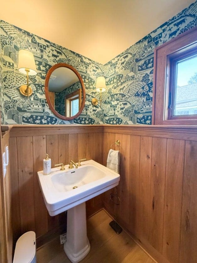 a bathroom with an oval mirror over the sink