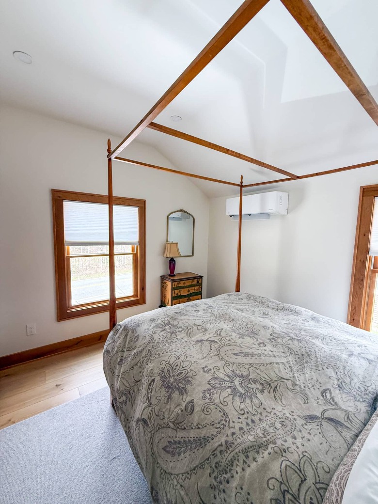 a bed in a bedroom with a window by the dresser