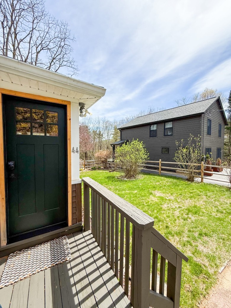 a door of a house and a view of a nearby house