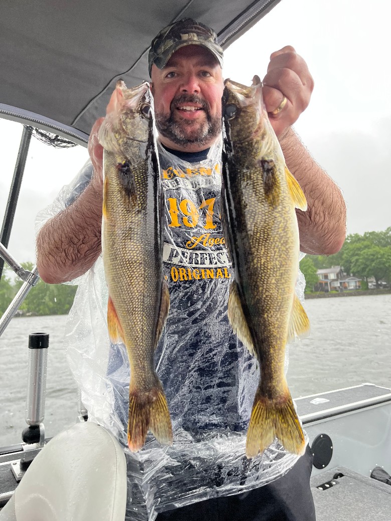 a man holding up two fish