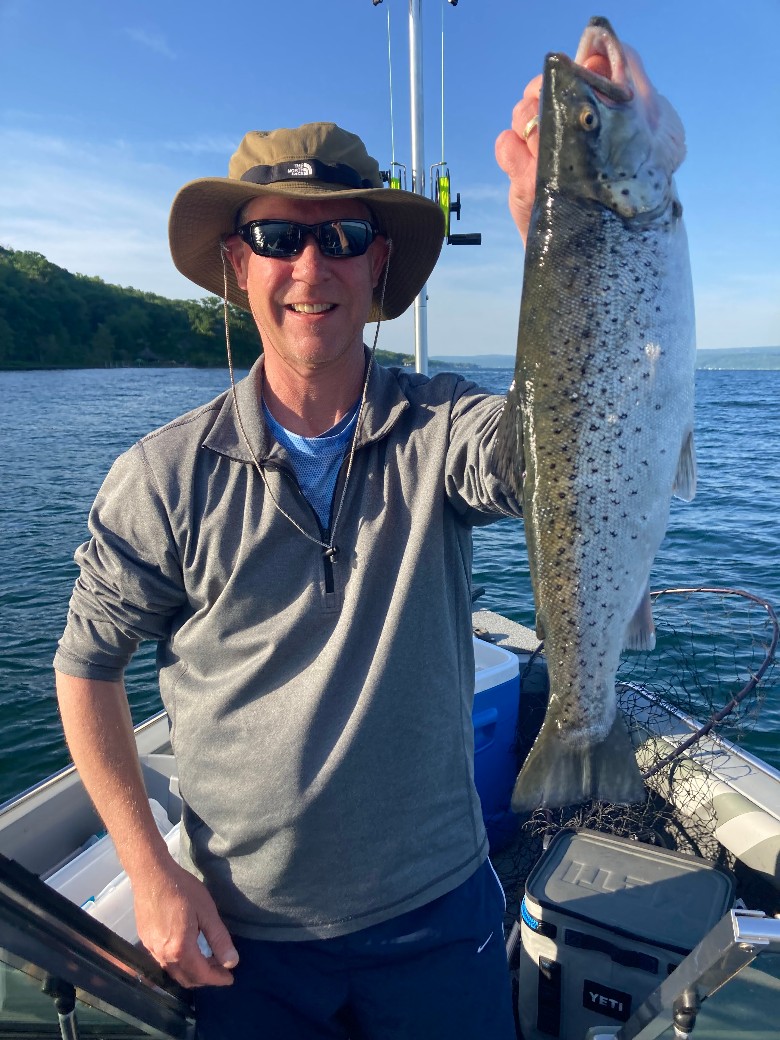 a man holding up a fish on a boat
