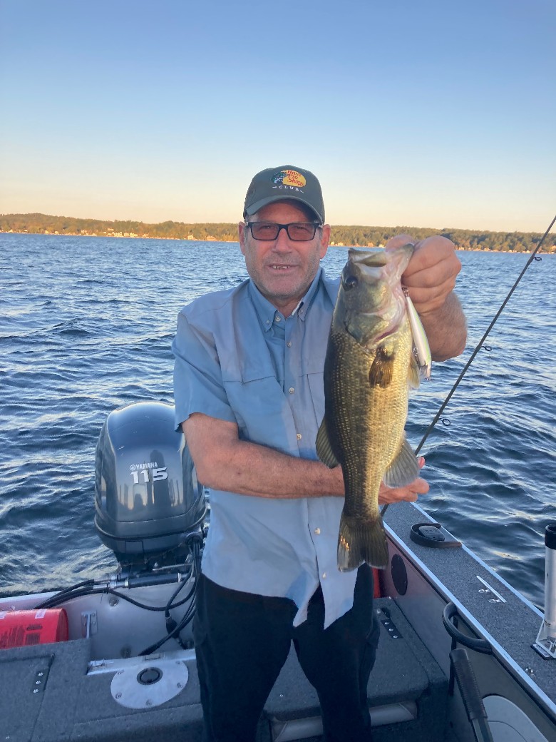 a man holding up a fish on a boat