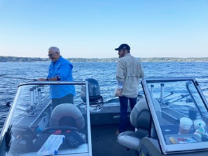 two men near fishing poles on a boat