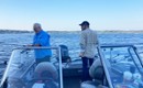 two men near fishing poles on a boat