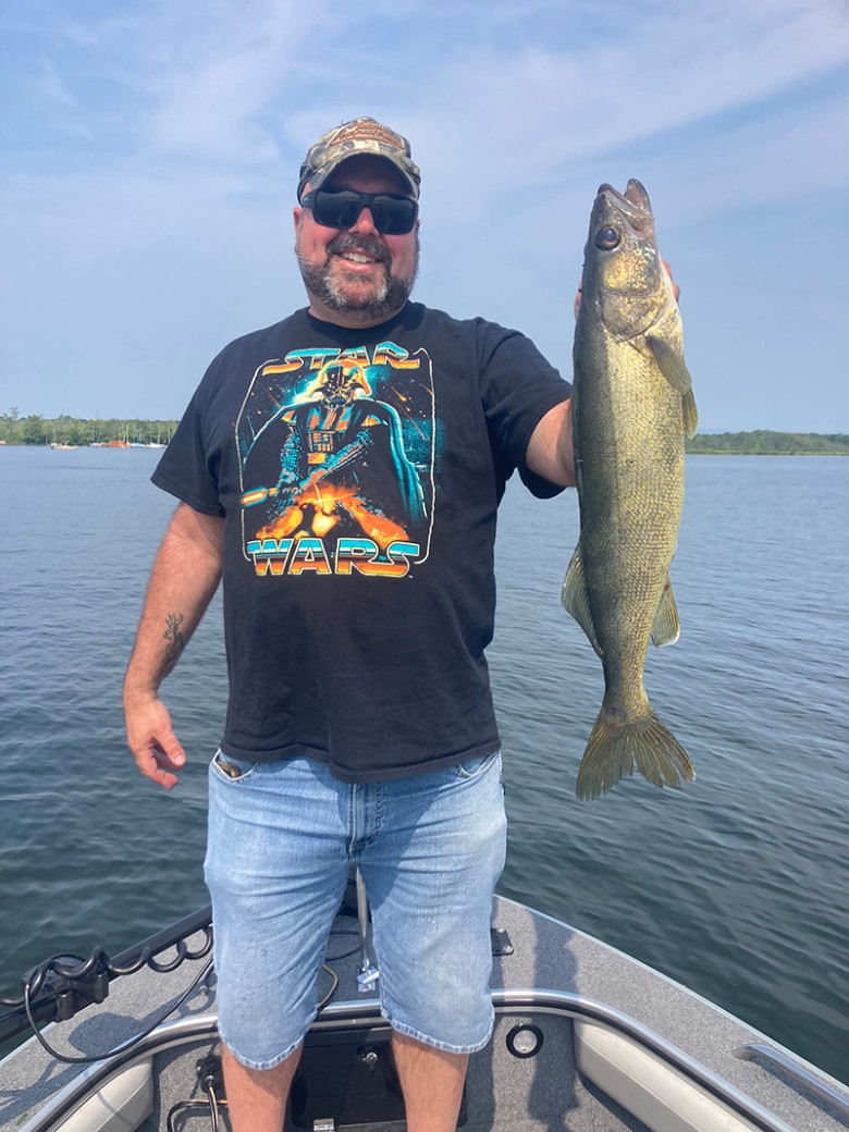 a man holding up a long fish