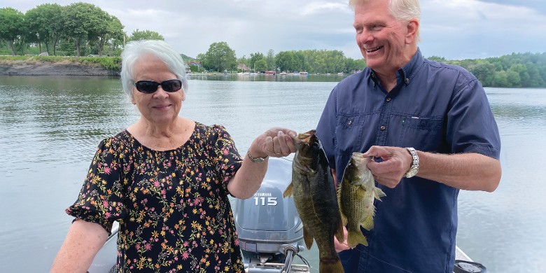 a man and woman holding up fish
