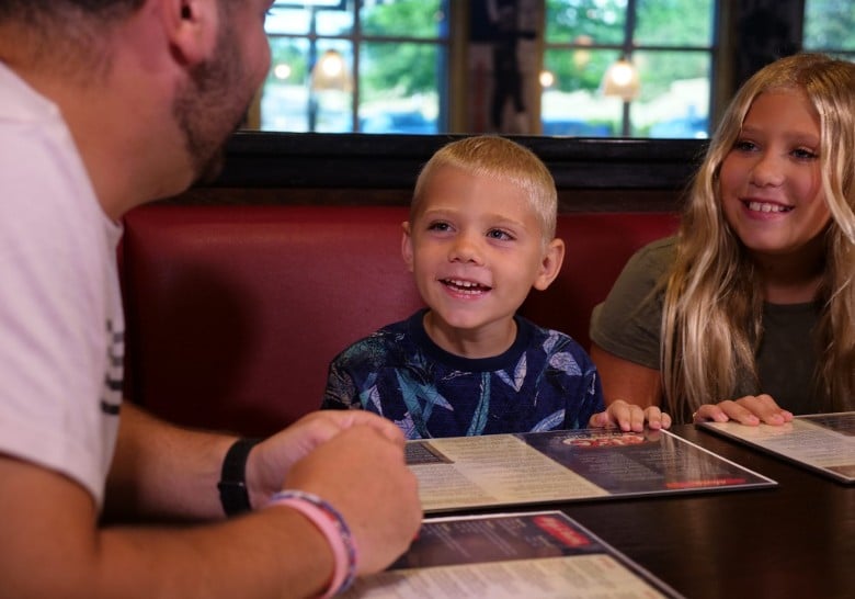 a father with a boy and girl at a restaurant table