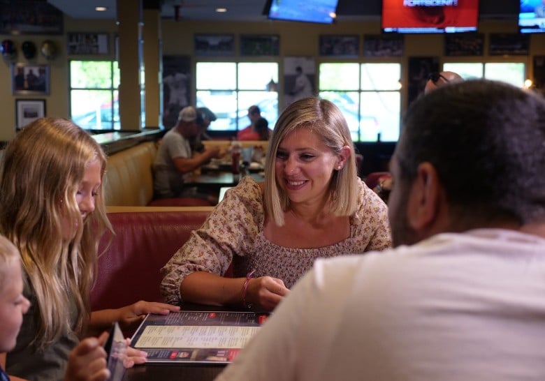 a woman, man, and two kids at a restaurant table