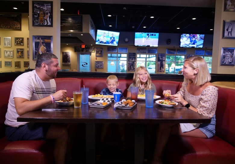 a woman, man, and two kids at a restaurant table