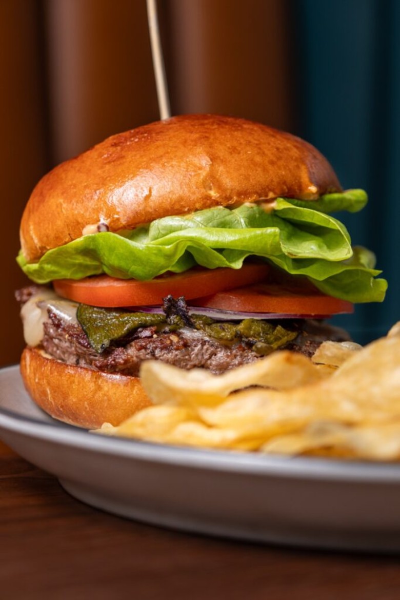 a burger loaded with lettuce and tomatoes