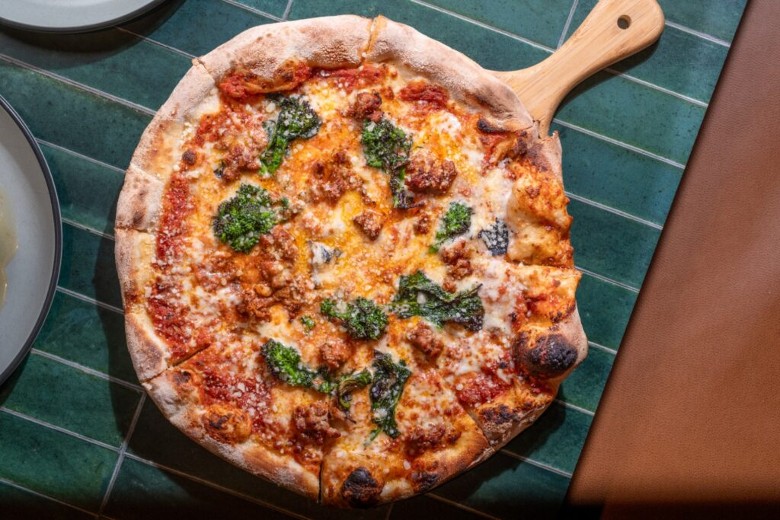 a pizza with cheese and broccoli