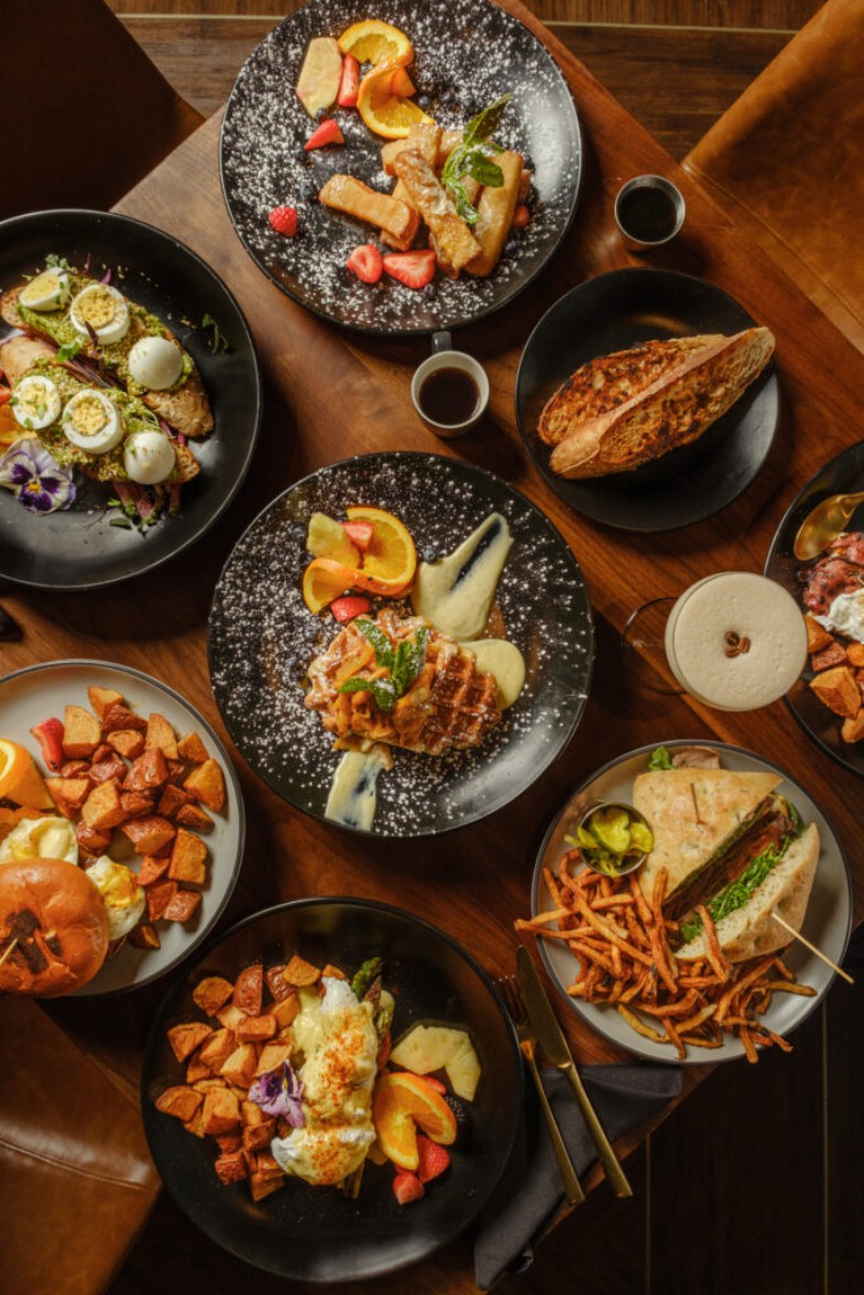 an assortment of brunch food like waffles and sandwiches on a table