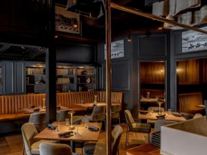 an upscale restaurant dining room with tables, and books on the walls