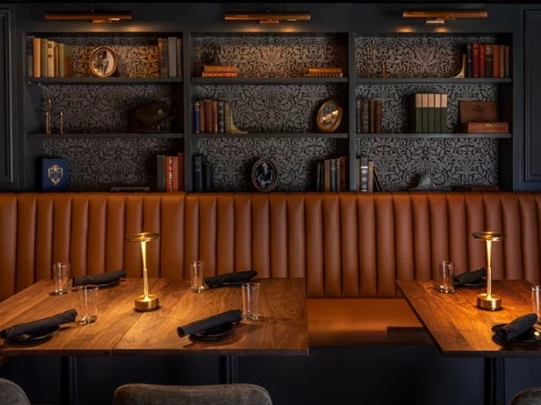 restaurant booth and table seating with books on the wall