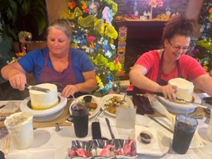 two women working on frosting two cakes