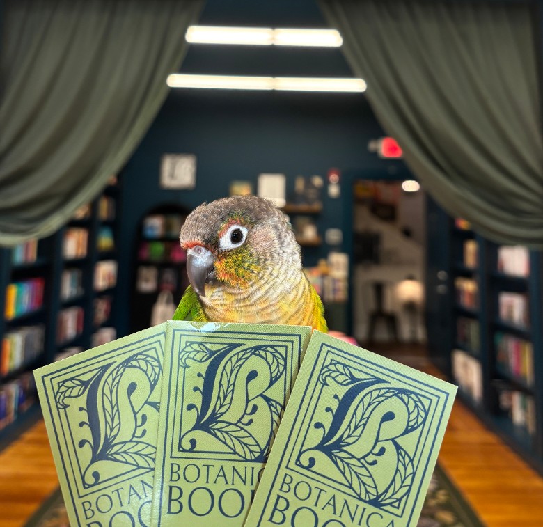 parrot looking at botanica books bookmarks