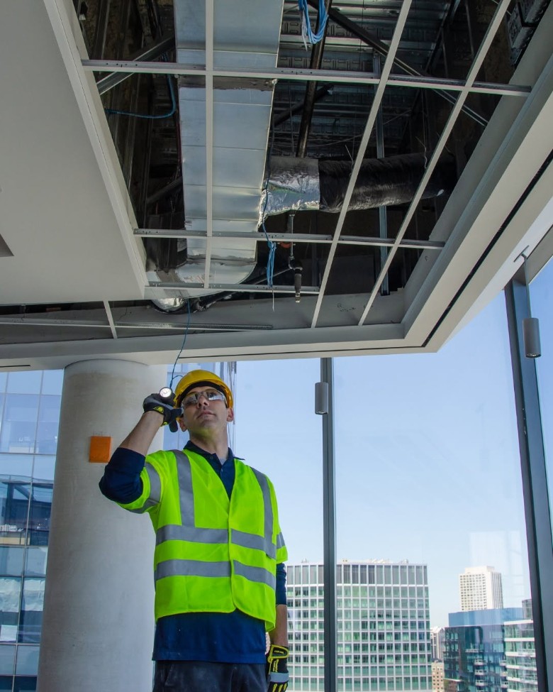 technician looking at ceiling of building